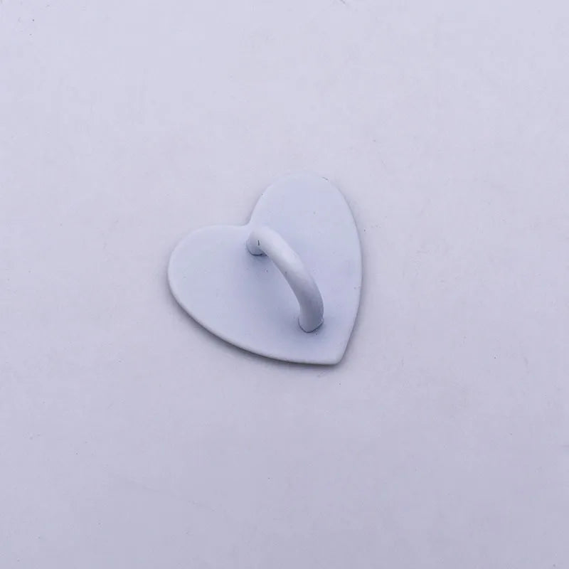 A small, smooth, white metal heart-shaped phone charm connector.