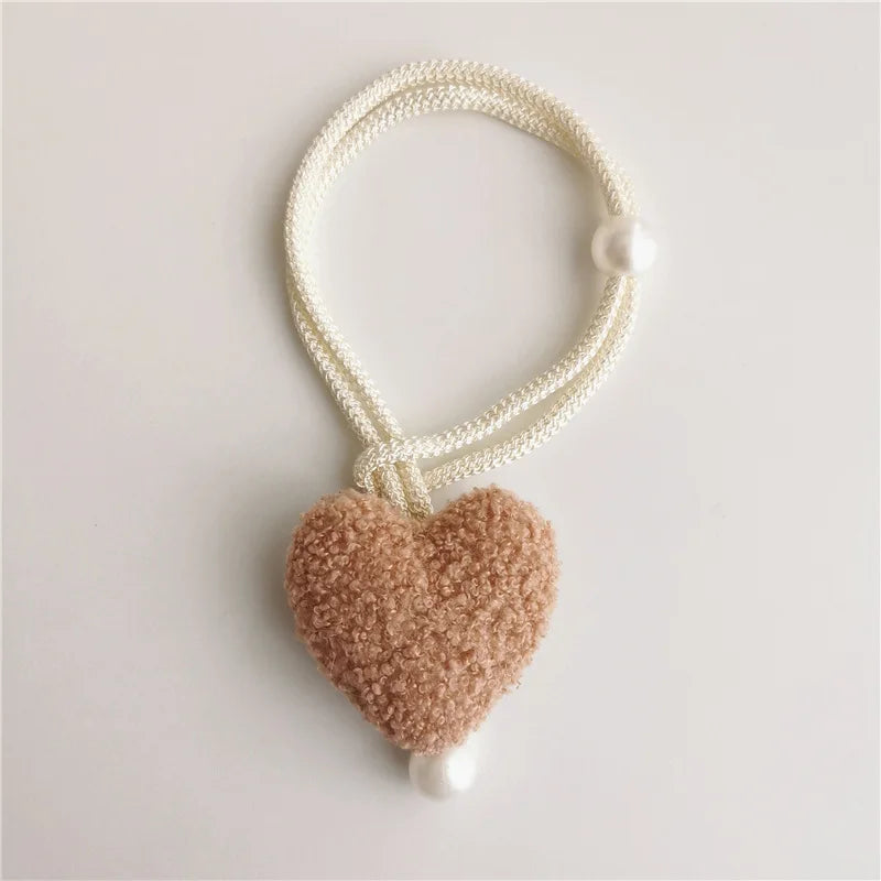White pearl beaded tiebacks with a fuzzy pink heart charm