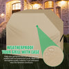 A beige waterproof cover protecting a grill outdoors in a stone building setting.