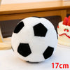 A white and black realistic football plush toy resting on a white surface.