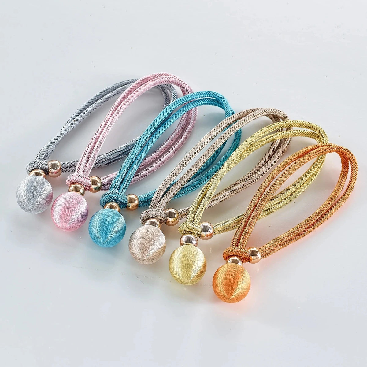 A set of two decorative rope pearl curtain tiebacks in various pastel colors like pink, blue, and gold.