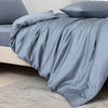 A light blue luxury bamboo duvet cover set draped over a bed, showing soft folds and fabric texture.
