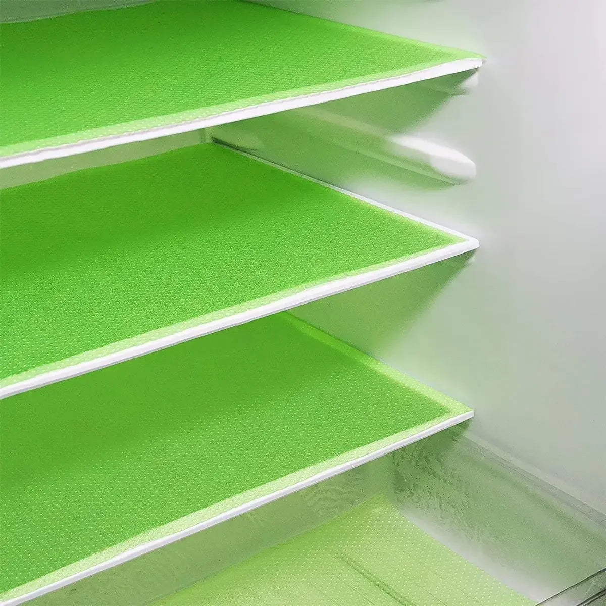 Three bright lime green reusable EVA fridge shelf liners installed in a refrigerator interior.