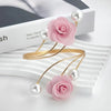 Pink rose pattern curtain ties with gold metal loops and pearl beads displayed on a white surface.