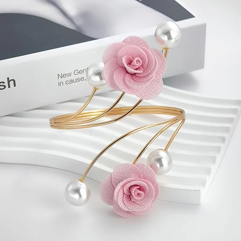 Pink rose pattern curtain ties with gold metal loops and pearl beads displayed on a white surface.