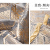 Close-up of a luxurious gold-colored velvet fabric texture with geometric patterns and a satin trim.