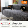A dark gray jacquard plush elastic sofa cover with a black cushion displayed on a sofa.