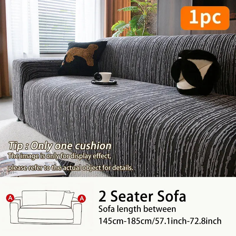 A dark gray jacquard plush elastic sofa cover with a black cushion displayed on a sofa.