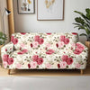 A floral patterned stretch sofa cover featuring pink and cream roses displayed indoors.