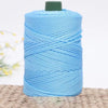 A spool of light blue 3mm ice rope crochet yarn for crafting resting on a woven surface.