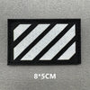 Black fabric patch with white diagonal stripes on a gray background
