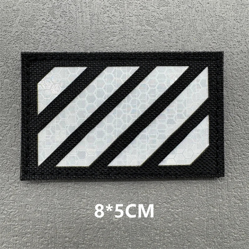 Black fabric patch with white diagonal stripes on a gray background