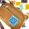 A tan canvas iron-on patch bag with a zipper and various motivational text patches