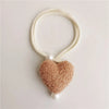 White pearl tiebacks with a fuzzy pink heart charm
