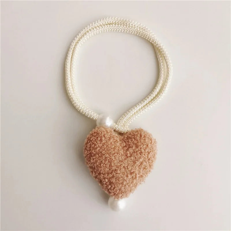 White pearl tiebacks with a fuzzy pink heart charm