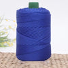 A spool of dark blue 3mm ice rope crochet yarn with a green cap resting on a woven mat.