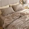 A beige princess ruffle cotton bedding set with white accents and pillows on a bed.