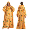 A woman wearing a yellow sherpa fleece oversized blanket hoodie, shown from the front and back.