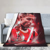 A red and black graphic featuring a male face with a glowing effect on a wool throw blanket.