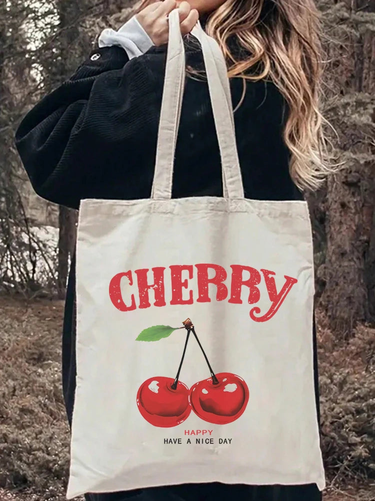 A white canvas shopping bag with red lettering spelling out CHERRY and a graphic of cherries.