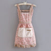A pink floral pattern kitchen apron with a bib and adjustable strap hanging on a wooden hanger.