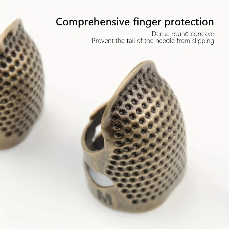 A close-up view of a bronze sewing thimble and needle protector with a dense round concave design.