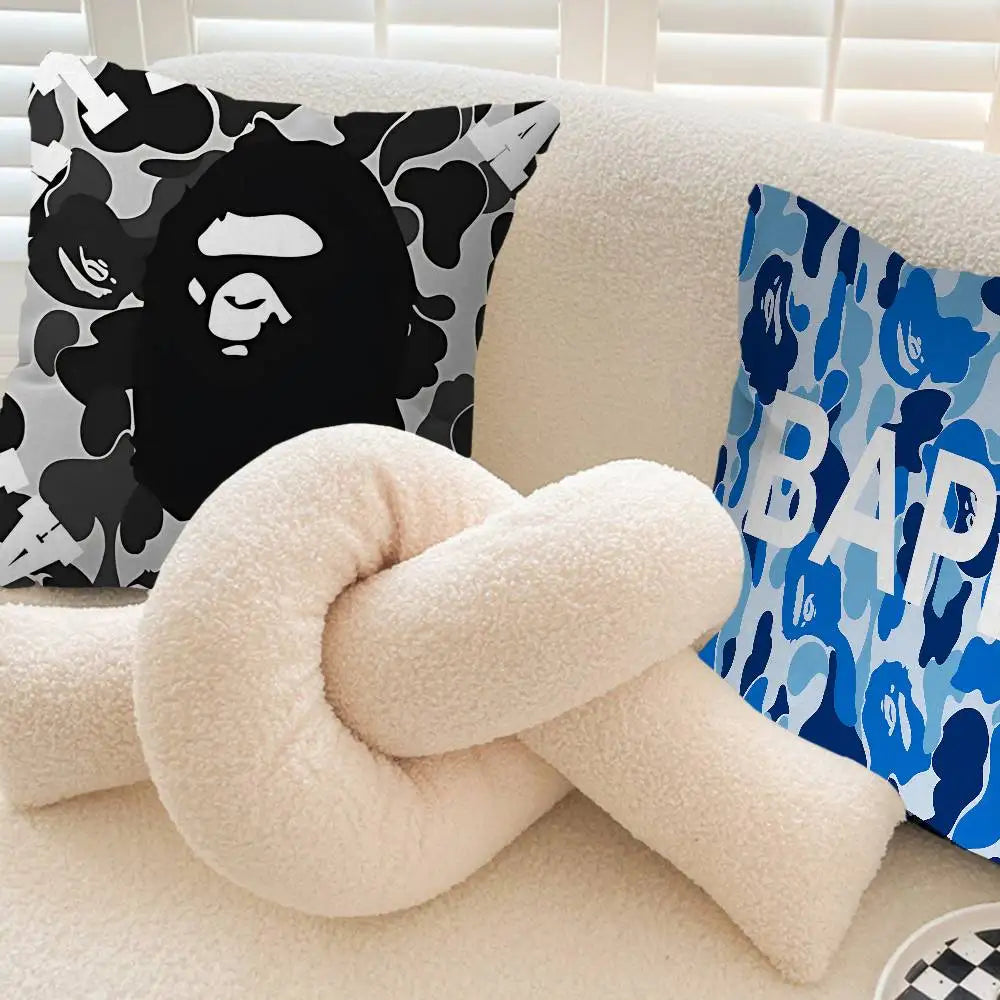 A cream-colored knitted pillow cover is rolled and placed on a light sofa next to patterned pillows.