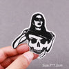 Black embroidered patch featuring a skull and crossbones design on a light gray background