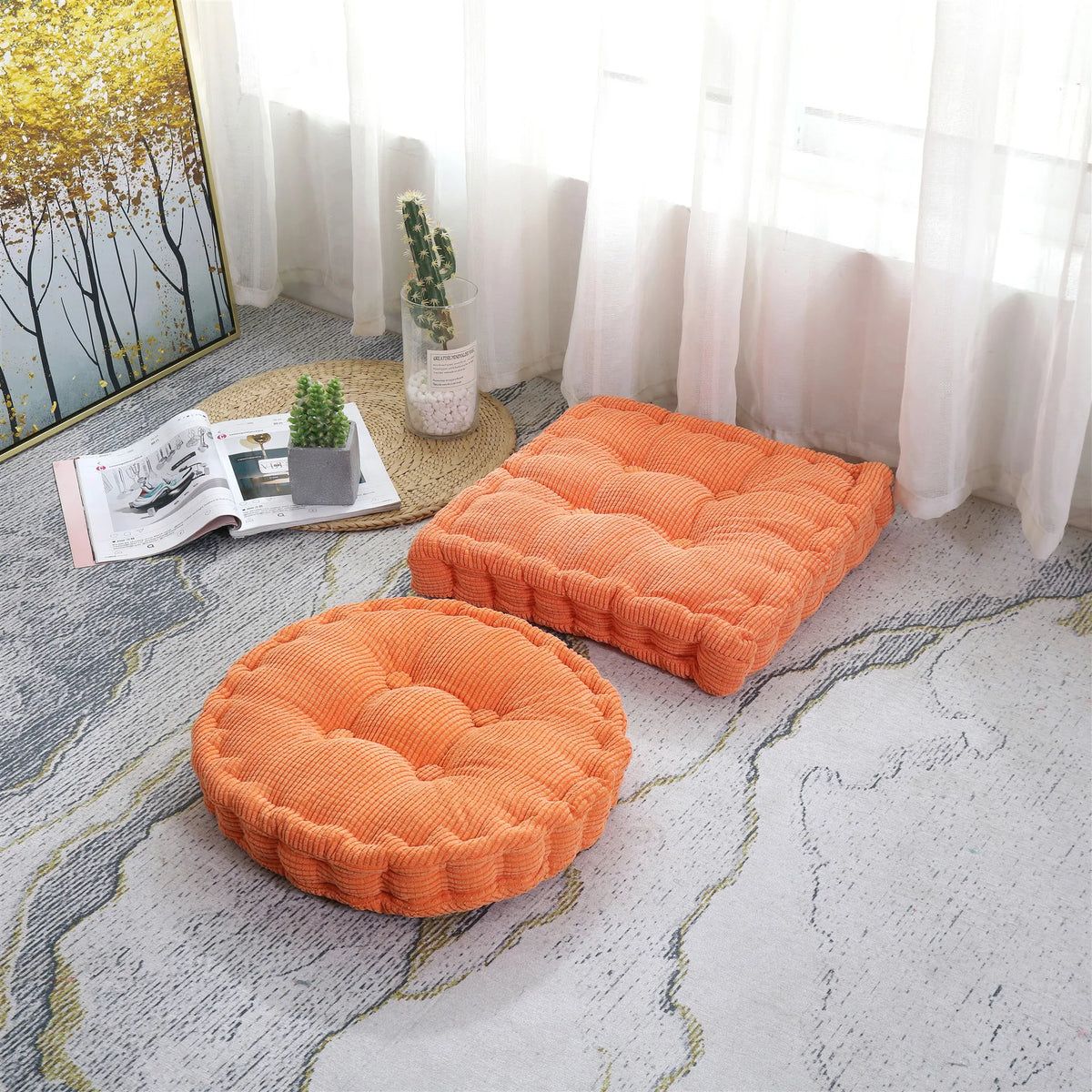 An orange tufted corduroy floor seat cushion resting on a light gray patterned floor near a window.