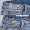 Close-up of a denim jean waistband featuring decorative metal waist pin buckles