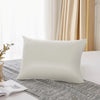 A white pure mulberry silk pillowcase resting on a gray linen fabric in a bright room.