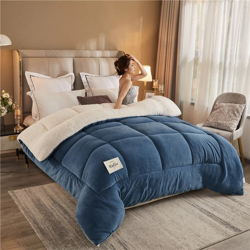A deep blue weighted fleece blanket is displayed on a bed, with a person resting their hand on the blanket.
