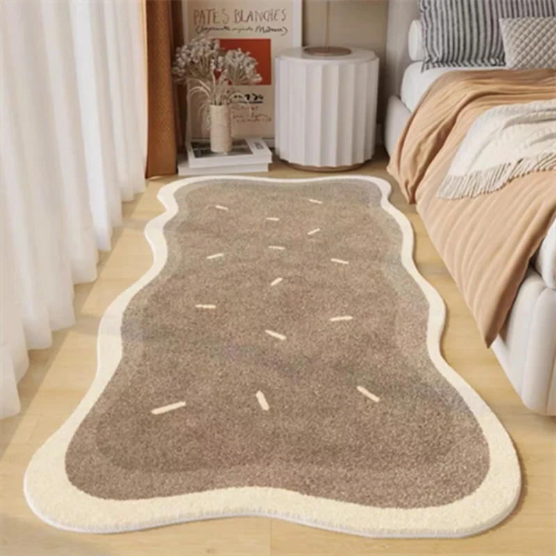 A rectangular beige rug with light brown accents is placed on a wooden floor next to a white sofa.