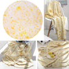 A yellow and white patterned blanket throw featuring a pizza design, shown draped over a chair and folded.