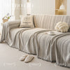 Elegant fishbone pattern sofa cover in beige and gray tones draped on a light-colored sofa.