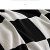 Close-up of a black and white checkered fabric texture, showing the knit pattern.