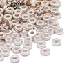 A pile of small, silver-toned acrylic flat round spacer beads for DIY jewelry.