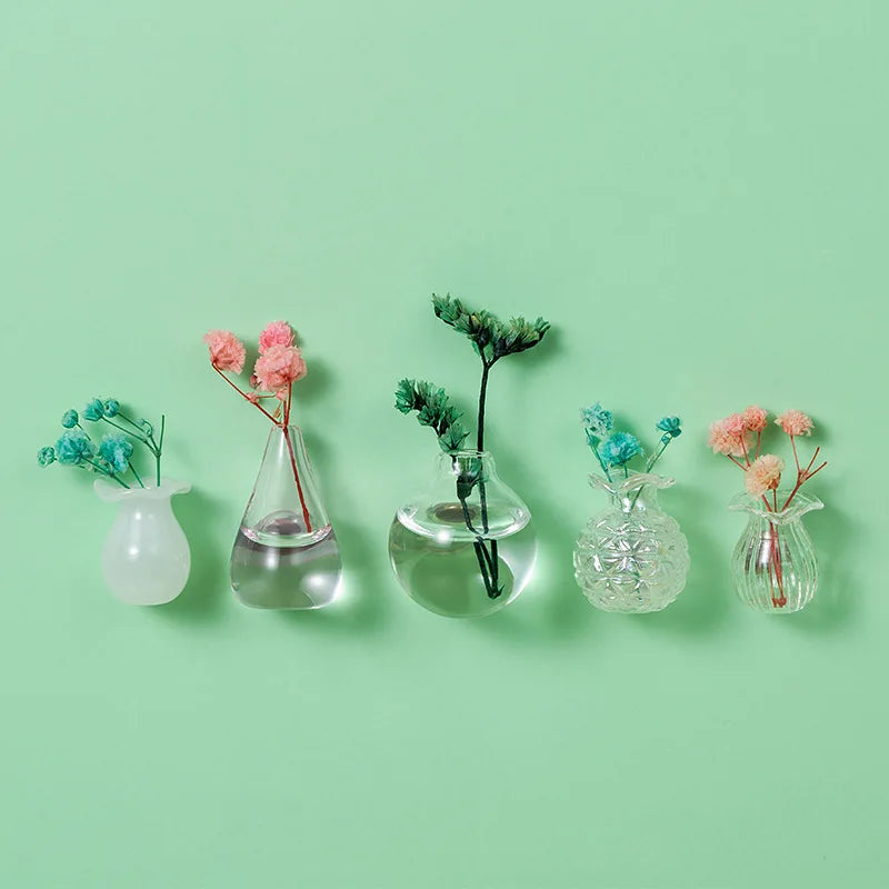 A collection of mini ceramic landscape fridge magnets featuring pink and blue floral designs on a light green background.