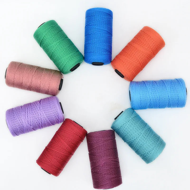 A collection of hand knitting and crochet cord in various colors including green, blue, orange, purple, and pink rolled into 