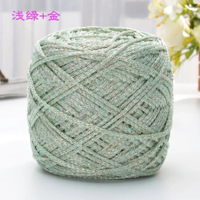 A ball of metallic silver-green silk yarn used for crocheting and knitting.