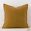 A solid mustard yellow chenille throw pillow with a scalloped edge.