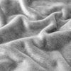 Close-up of a soft gray double-sided sherpa fleece blanket fabric draped and folded.