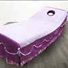 Purple and white disposable non-woven beauty and salon sheet with a circular hole