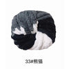 A ball of chunky gray and black acrylic yarn for knitting and crochet projects.