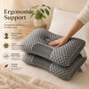 A gray ergonomic pillow is shown next to a hand, highlighting its contoured design for neck and head support.