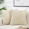A set of four neutral corduroy throw pillow covers with a vertical ribbed texture and patchwork design on a white sofa.