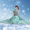 A woman is wrapped in a light green cooling blanket against a snowy, blue background with falling snowflakes.