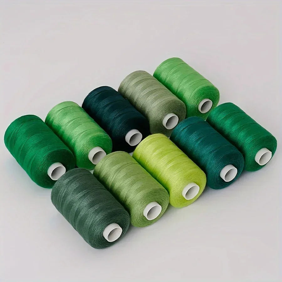 A collection of ten rolls of high-quality polyester sewing thread in various shades of green and dark blue.