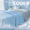 A light blue quilted blanket draped over a bed, with ice or water effects in the background.