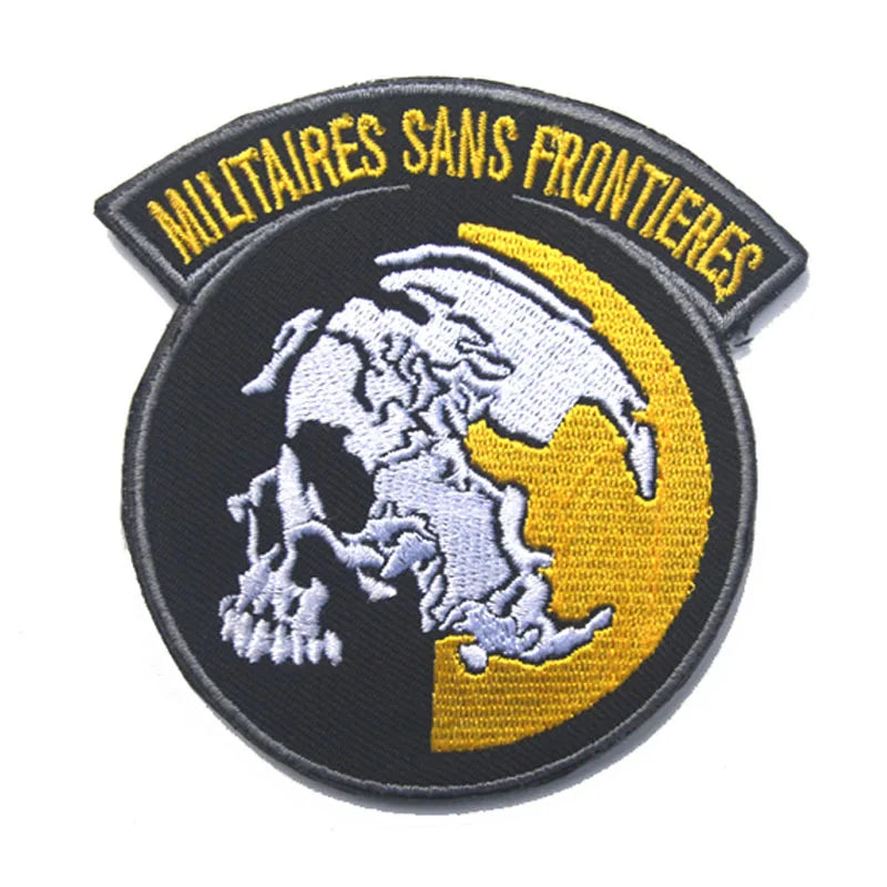 A round black military patch featuring a white foxhound skull silhouette against a yellow circle and gold lettering.